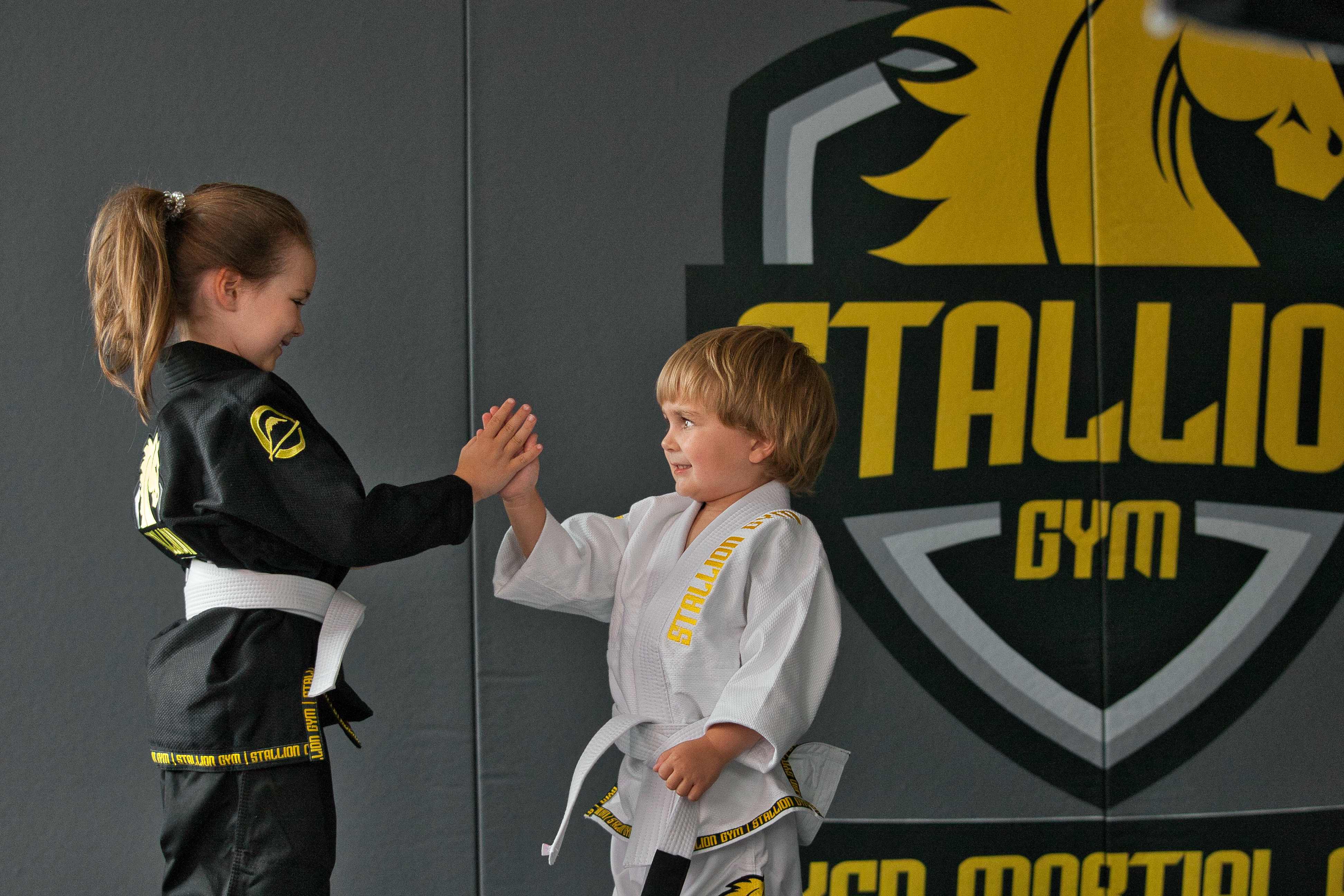 Kinder beim High-Five nach dem Training im STALLION GYM - Teamgeist und Freundschaft