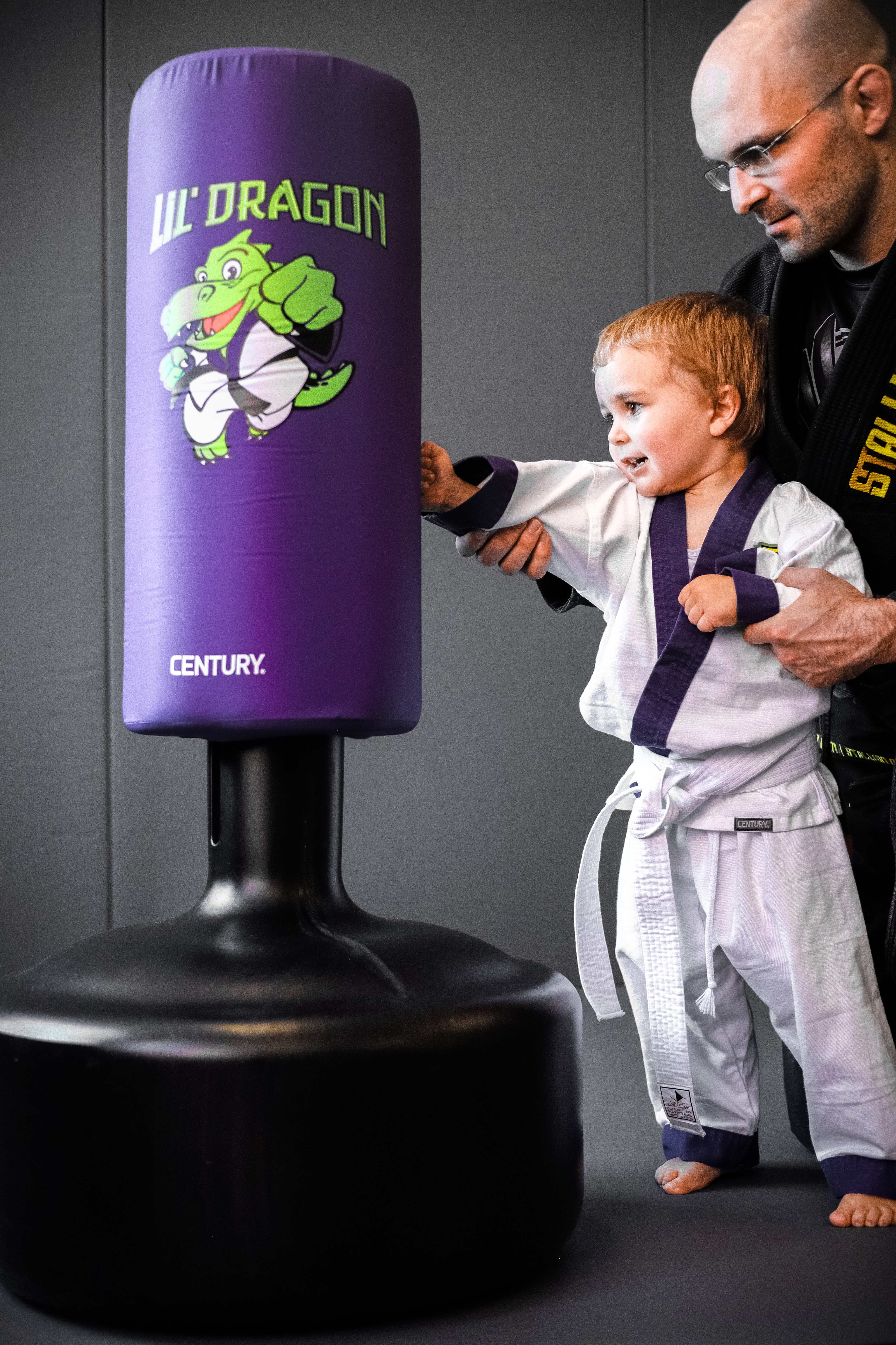 Lil Dragon Training - Kind trainiert am Sandsack mit Trainer